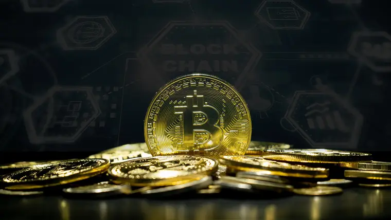 Bitcoin token resting on a laptop keyboard showing a block explorer