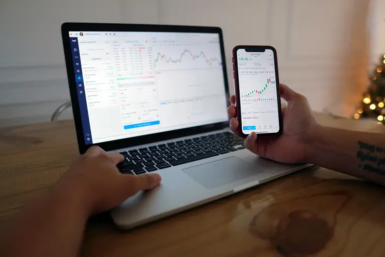 Notebook, calculator and financial charts laid out on a desk